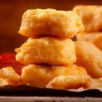 У курицы на теле нет области под названием "наггетс". Слово "Nuggets" переводится с английского как "самародок". Наггетсы обычно приготавливаются из куриного грудного мяса, которое нарезается на маленькие кусочки, которые затем обваливаются в яйце, муке и панировочных сухарях. Затем наггетсы обычно жарятся во фритюре до золотистого цвета и подаются с соусом.